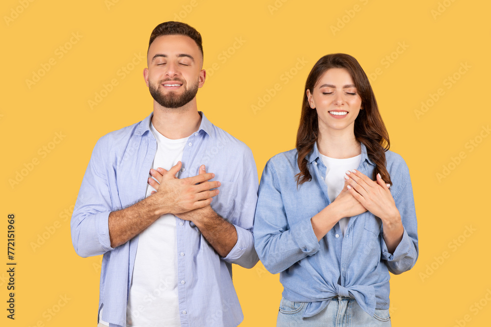 Man and woman showing gratitude with hand on chest Man and woman showing gratitude with hand on chest