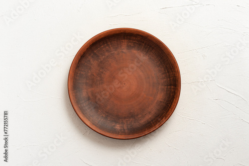 Empty clay plate on a white background.