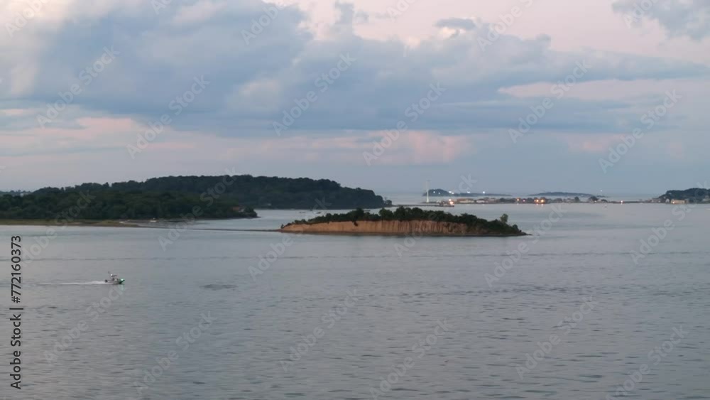 Drone captures a motorboat going along the lake at sunset with cliffs in the background Drone captures a motorboat going along the lake at sunset with cliffs in the background