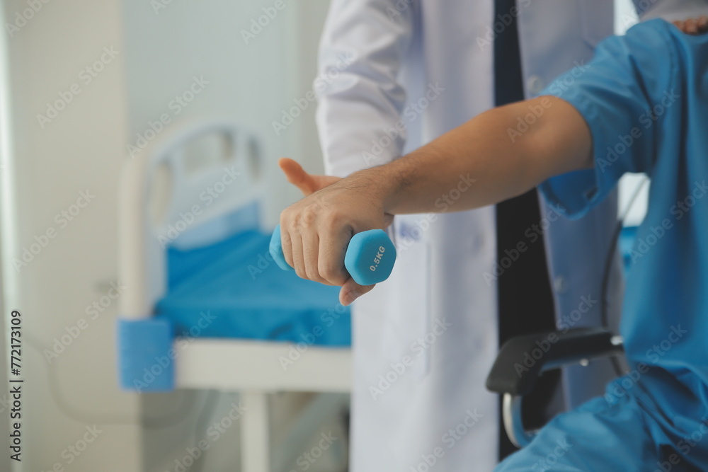 Physiotherapist man giving exercise with dumbbell treatment About Arm and Shoulder of athlete male patient Physical therapy concept Physiotherapist man giving exercise with dumbbell treatment About Arm and Shoulder of athlete male patient Physical therapy concept