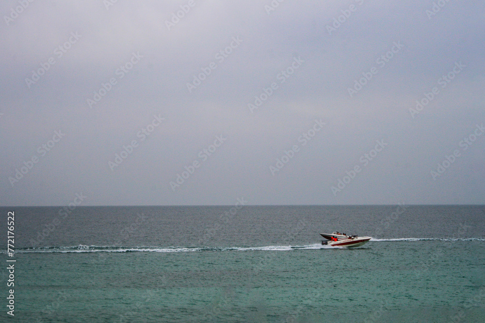 Speedboat in the sea on the background of the cloudy sky indicating water activities and sports.