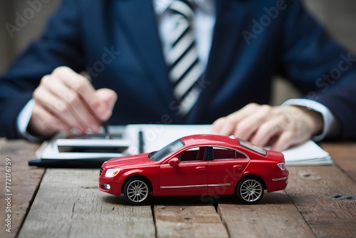 Toy car in front of businessman calculates car loan