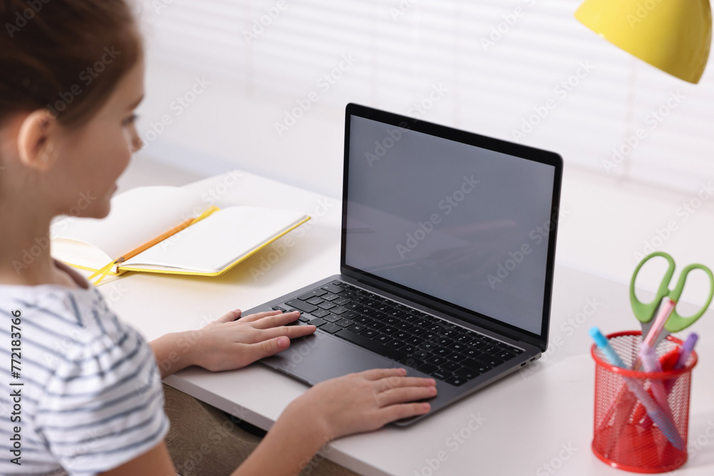 E-learning. Girl using laptop during online lesson at table indoors, closeup E-learning. Girl using laptop during online lesson at table indoors, closeup