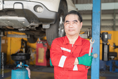 Male mechanic working at garage. Professional Asian male mechanics checks, repair and maintenance at auto car repair service. Car service and Maintenance concept