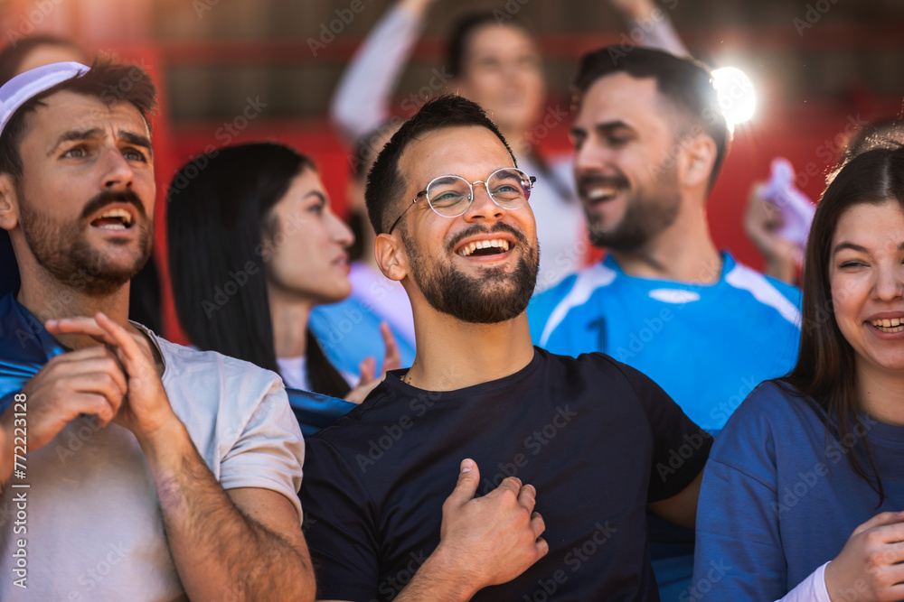 Football / soccer fans are cheering for their team at the stadium on the match