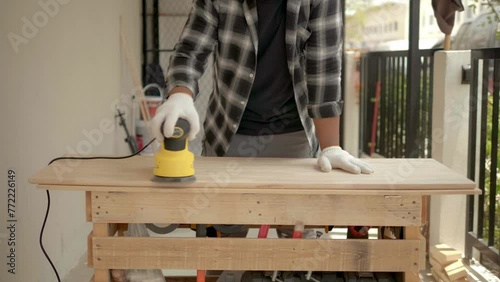 Young man operating a sander polishing sandpaper on his wooden floor. Seasonal house chores, woodworking, restoration. capturing the essence of a do-it-yourself concept.