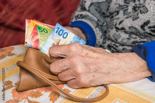 A pensioner in Switzerland counts money, Swiss francs - problems of older people, financial concept