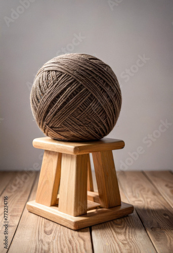 A skein or boll of soft yarn on a wooden stand on a simple background, world wide knit day