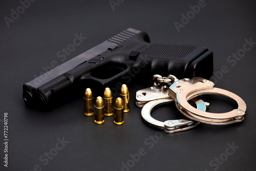 Hand gun with ammunition on dark background. 