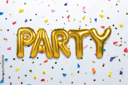 Creative composition made with Party foil balloon and party confetti on white background. Minimal celebration party concept.