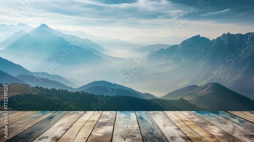 Misty mountains with morning light on wood deck - A serene dawn breaks over mist-covered mountains, seen from a weathered wooden deck viewpoint photo