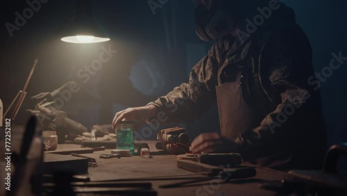 A man builds a bomb in his workshop at night