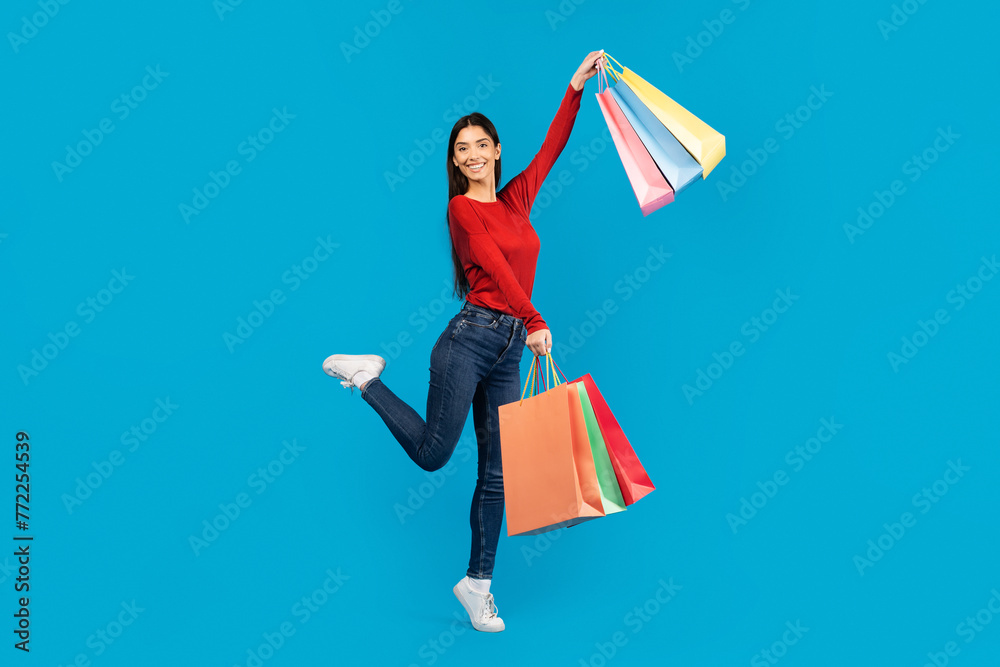 Excited Young Woman Holding Shopping Bags And Jumping In Air Excited Young Woman Holding Shopping Bags And Jumping In Air
