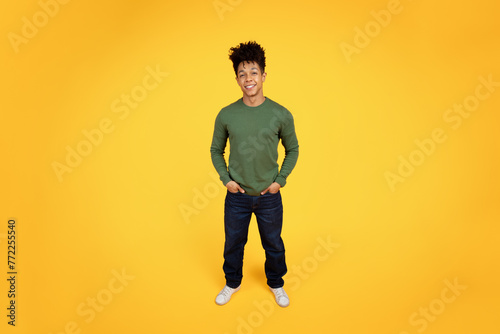 Confident african american guy standing with arms akimbo