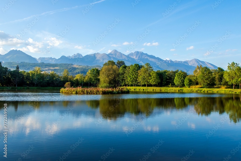 Scenic landscape featuring a tranquil lake and green trees on the shore. High Tatras, Slovakia.