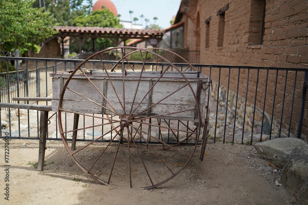 Broken wooden wagon in a field next to a wooden fence Broken wooden wagon in a field next to a wooden fence