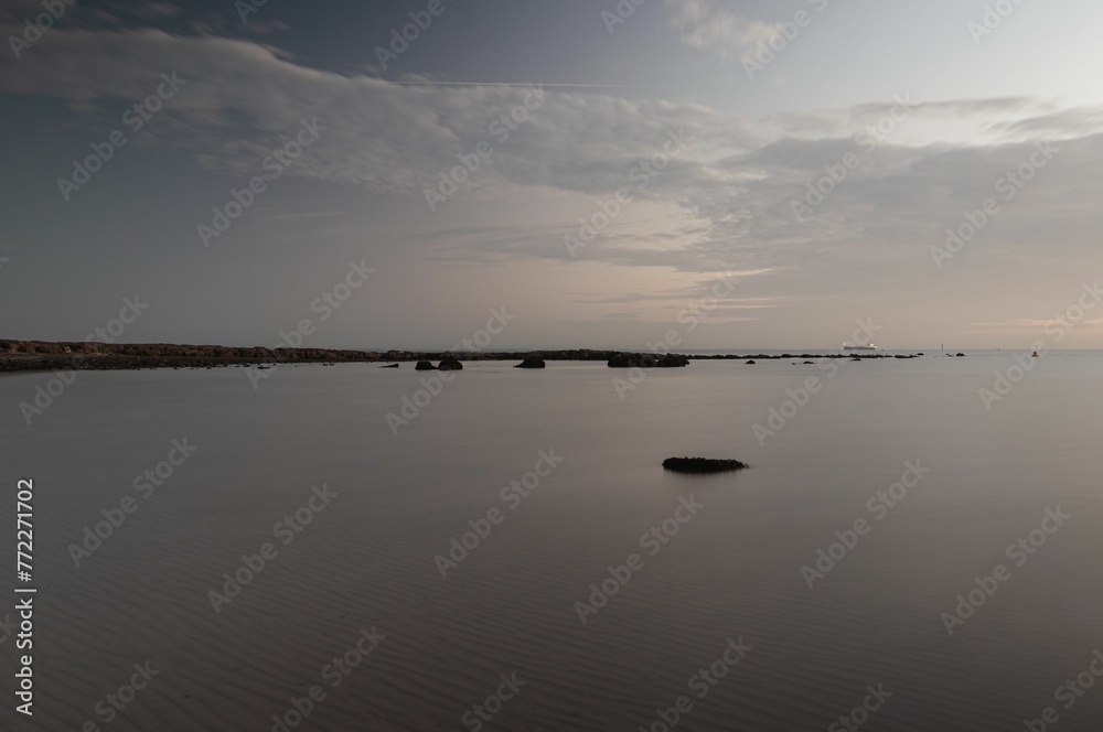 Scenic view of a tranquil lake surrounded by large rocks, with lush green foliage in the background Scenic view of a tranquil lake surrounded by large rocks, with lush green foliage in the background