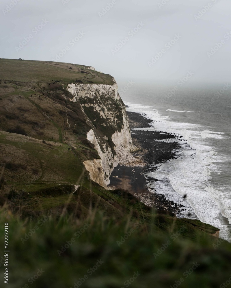 Coastal landscape with a white-chalked beach surrounded by steep cliffs, the White Cliffs of Dover