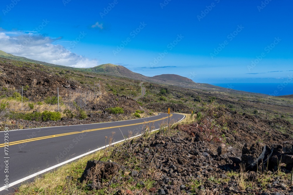 Aerial view of a winding road leading up to the coastline of a tranquil ocean Aerial view of a winding road leading up to the coastline of a tranquil ocean