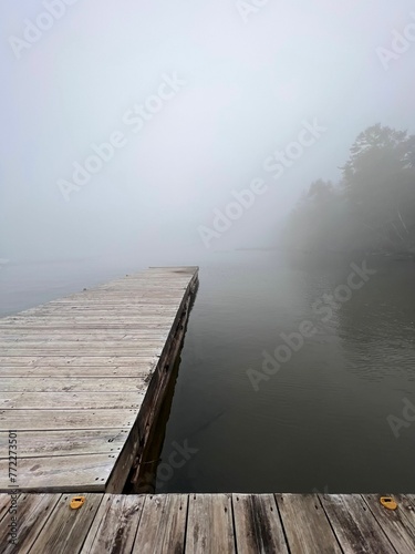 Fototapeta Naklejka Na Ścianę i Meble -  Picturesque dock on a tranquil lake surrounded by a foggy atmosphere