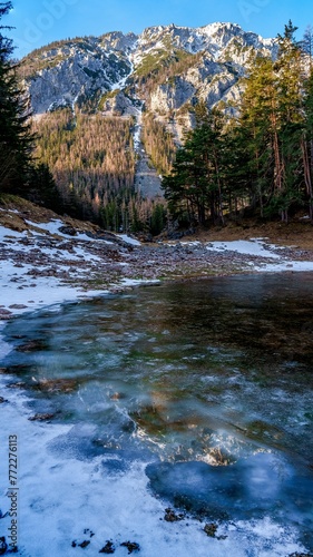 Tranquil winter scene featuring the frozen Green Lake and snow covered mountains in Styria, Austria