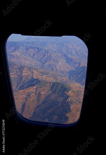 View of mountain range seen through an airplane window during sunset photo