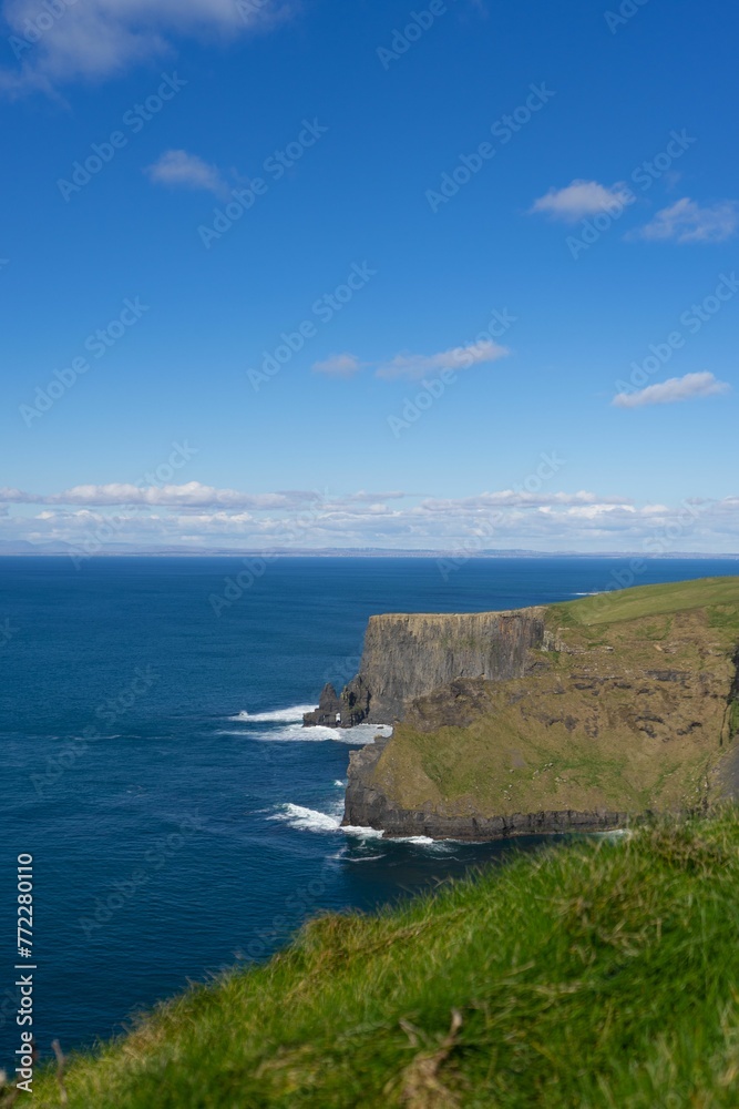 Stunning landscape featuring a rocky shoreline with blue ocean waters. Cliffs of Moher, Ireland. Stunning landscape featuring a rocky shoreline with blue ocean waters. Cliffs of Moher, Ireland.