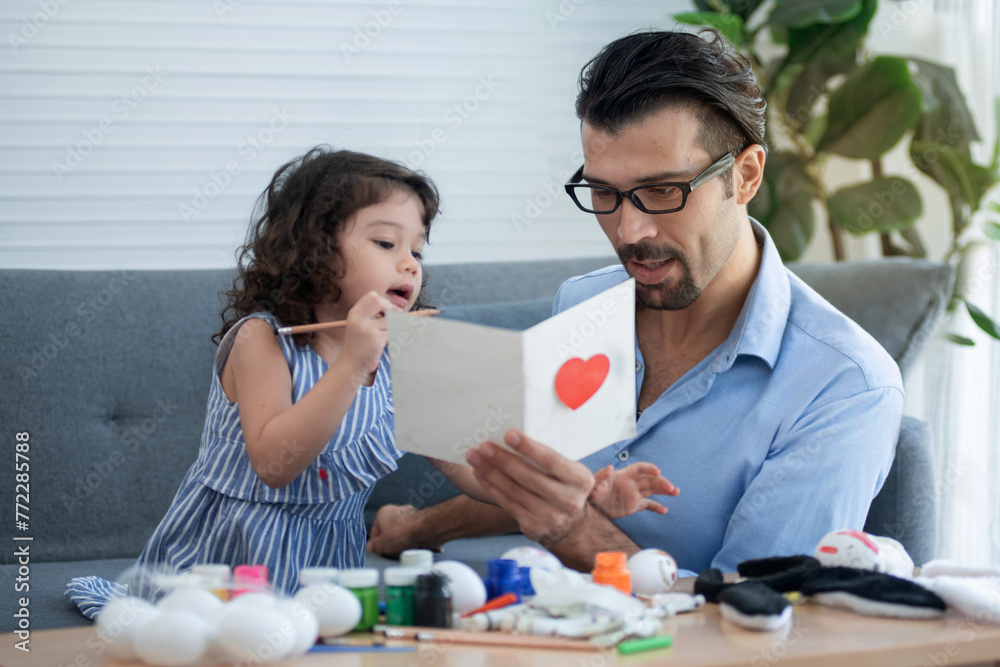 Little girl shows her father a card she made herself, and give a card to dad on Father's Day Little girl shows her father a card she made herself, and give a card to dad on Father's Day