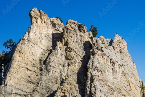 Aerial view of rugged rock formations majestically against a pristine blue sky in Colorado