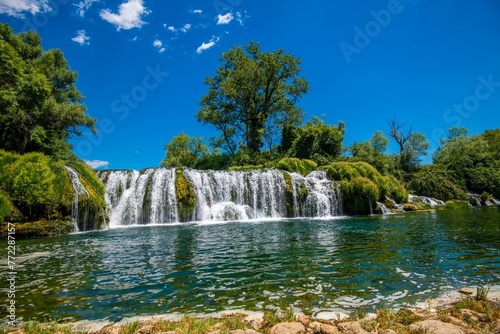 Majestic Kravica Waterfall cascading down amidst lush greenery and trees in Bosnia and Herzegovina