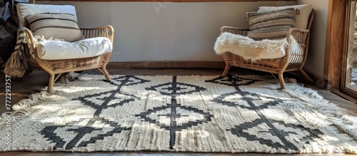 A living room featuring two chairs and a wool rug with a geometric pattern handmade in Moro.