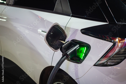 Electric cars parked at charging stations at night have status lights. It uses clean energy that is environmentally friendly and is becoming very popular nowadays.