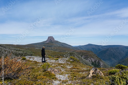 Beautiful shot of a person standing on top of Cradle Mountain in Tasmania, Australia