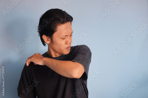 Young Asian man wearing black t-shirt, smelling body odor, stinky and disgusting, intolerable smell. Bad smells concept.