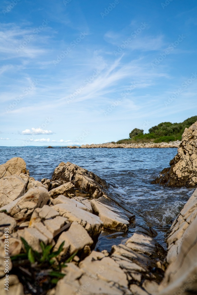 Vertical shot of a beautiful sunny rocky shoreline in Croatia