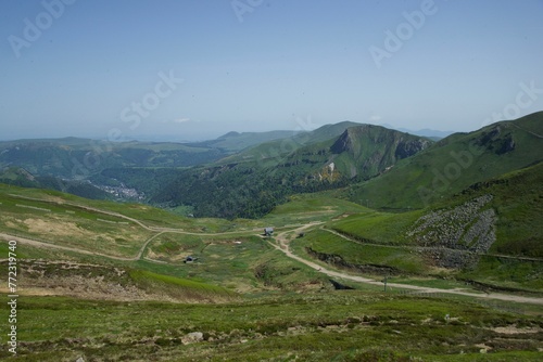 Scenic landscape of a winding green valley surrounded by majestic mountains