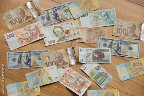 Different world currencies texture. Different currencies of different countries on the table: US dollars, Canadian dollars, zlotys, hryvnias, Czech crowns, euro