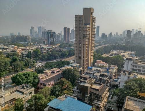Mumbai, India - 10 March 2024: Rural to urban development of mumbai in sion west with trees and skyscrapers in background photo