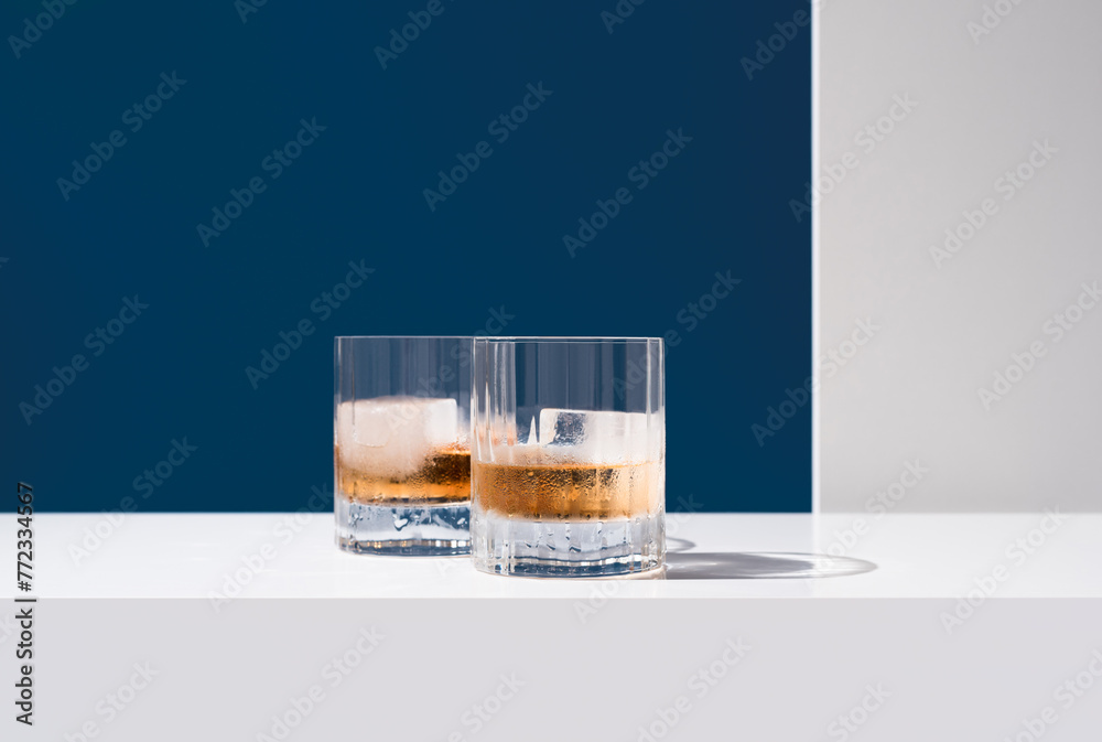 Dos vasos de whisky con hielo sobre un fondo azul	
 - obrazy, fototapety, plakaty 