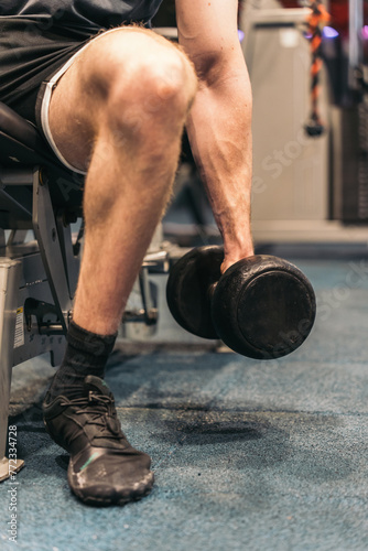 Close-up of Anonymous Athlete Holding Dumbbell for Bicep Curl. Close-up of anonymous athlete holding dumbbell for bicep curl, arm extended.