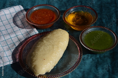 Siddu, a special traditional dish of Himachal Pradesh. It's a steamed wheat flour bread stuffed with split black  lentils, dry fruits etc. Served with desi ghee ,tomato and green mint chutney.  photo