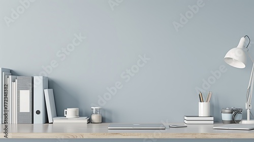 A modern office desk set against a pale blue wall, neatly arranged with books and supplies, and ample copy space for text or product display. copy space for text.