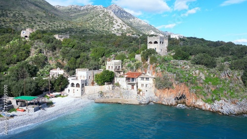 Alypa Beach, Mani Peninsula, Lakonia, Peloponnese, Greece, a beautiful stone beach with a transparent and turquoise sea water and cave in a cliff - drone aerial view 