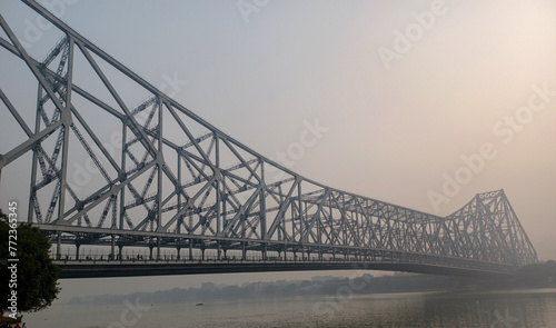 Kolkata, India, feb 26,2024: Historic Howrah bridge Kolkata at sunrise with view of the Ganges river ghat . Howrah bridge is a famous cantilever bridge and the busiest in India.