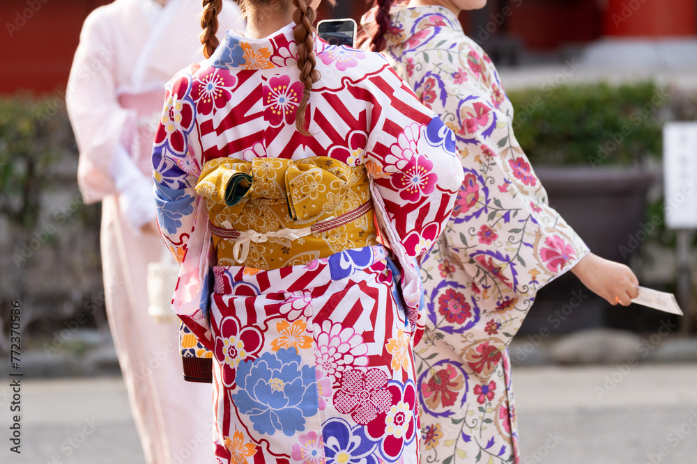 Young girl wearing Japanese kimono standing in front of Sensoji Temple in Tokyo, Japan. Kimono is a Japanese traditional garment. The word Young girl wearing Japanese kimono standing in front of Sensoji Temple in Tokyo, Japan. Kimono is a Japanese traditional garment. The word