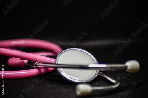 Ein pinkes Stethoskop auf schwarzen Hintergrund photo
