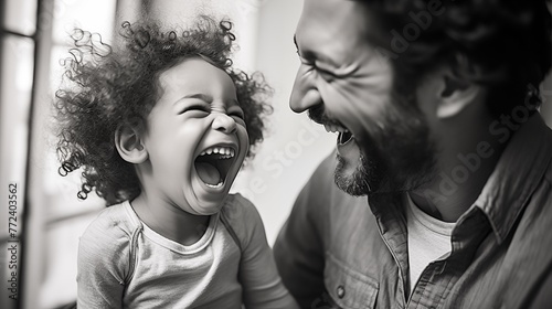 Father and child bond joyfully, sharing laughter and playtime, strengthening their connection through moments of shared happiness and amusement.
