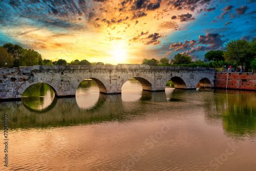 Roman ancient tiberius and augusto bridge over marecchia river in Rimini Italy at sunset or sunsrise