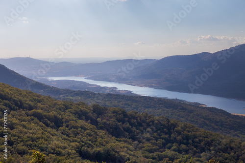 Landscape of the Jerte river with Plasencia reservoir, blue sky and windmills in the background. Jerte Valley, Spain photo