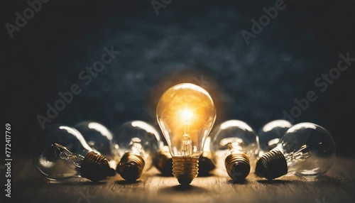 One of Lightbulb glowing among shutdown light bulb in dark area with copy space for creative thinking , problem solving solution and outstanding concept